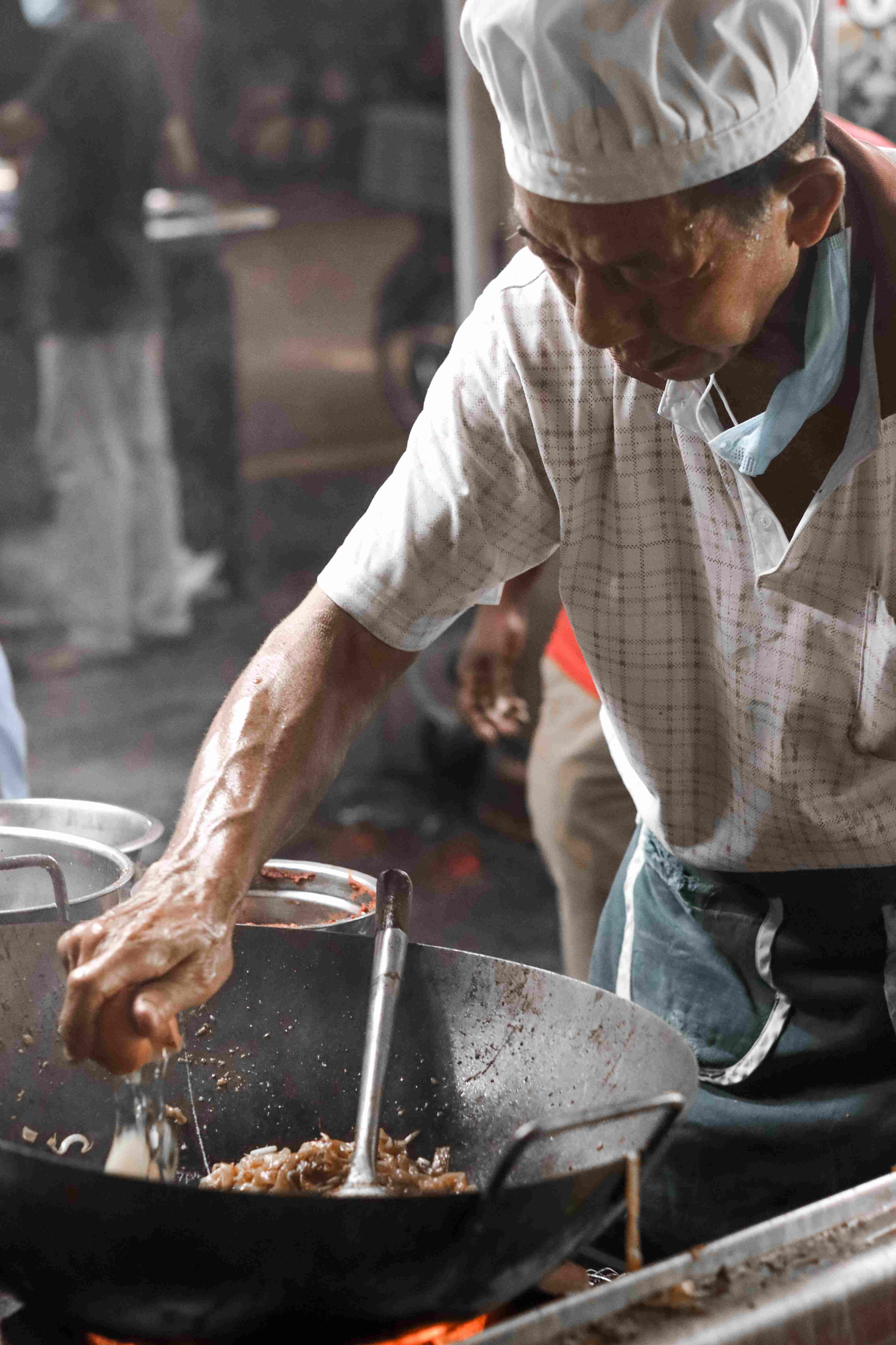 Man cooking in Penang, by Mark Chan on Unsplash